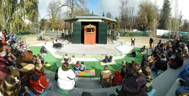 Escenario al aire libre del Teatro de Títeres en El Retiro con público sentado en gradas