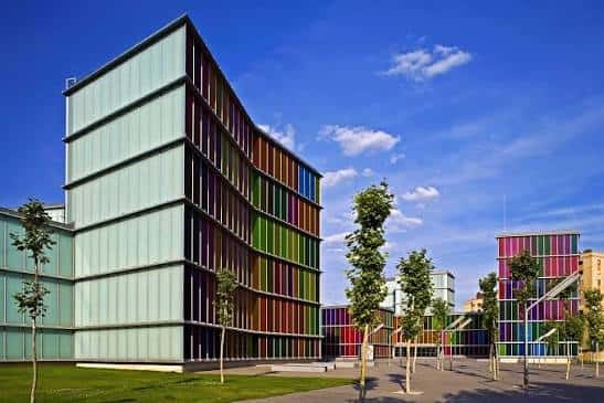 Ángulo exterior del edificio que resalta su estructura geométrica y entorno urbano