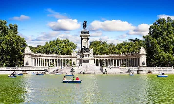 Monumento a Alfonso XII con barcas en el lago y cielo azul