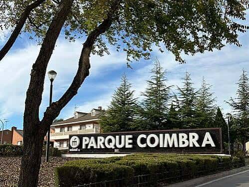 Entrada principal del Parque Coimbra con letrero y árboles