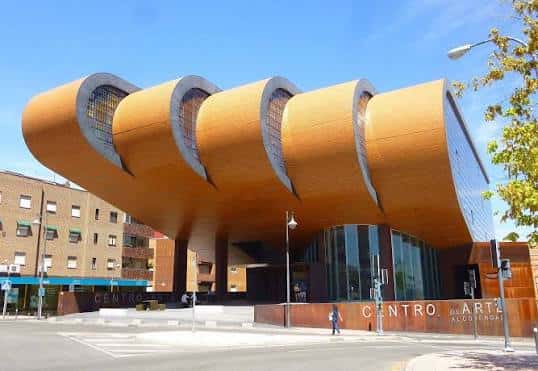 Vista frontal del Centro de Arte Alcobendas mostrando su icónica fachada de ladrillo curvado y estructura moderna bajo un cielo azul