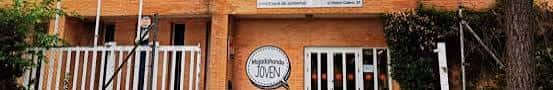Detalle de la entrada con letrero 'Majadahonda Joven' y portón blanco