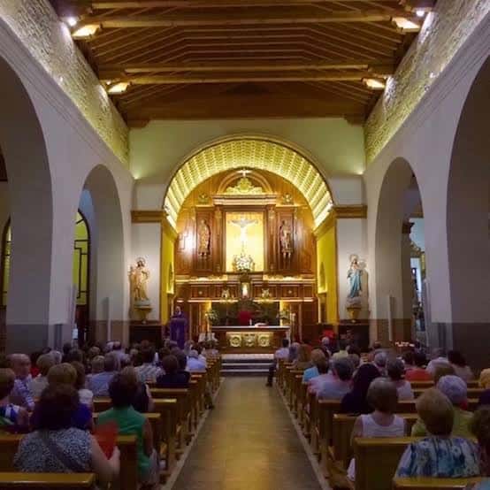 Interior de la Parroquia de San Pedro Apóstol con congregación durante una ceremonia