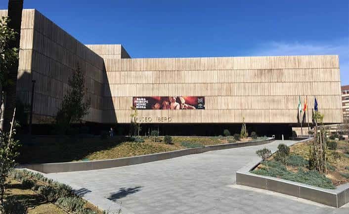 Fachada principal del Museo Íbero de Jaén con cartel de exposición y banderas