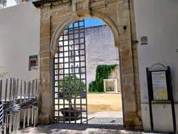 Detalle del arco de entrada principal con reja metálica y patio interior