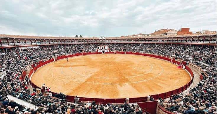 Plaza de toros llena de público durante un evento, vista aérea del ruedo y las gradas