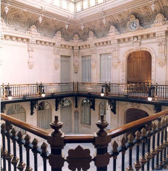 Vista del patio de luces interior con balcones ornamentados y reloj