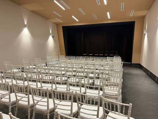 Sala de eventos del Centro de Interpretación Paco de Lucía con sillas blancas dispuestas para una ceremonia o conferencia
