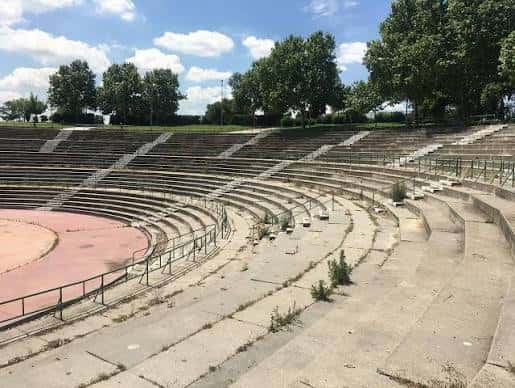 Vista general del anfiteatro al aire libre con gradas de hormigón y escenario circular