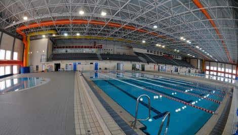 Vista panorámica de la piscina cubierta del Complejo Deportivo Ciudad de Cádiz con gradas y estructura metálica