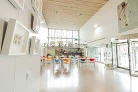Sala de exposiciones con mesas y sillas de colores