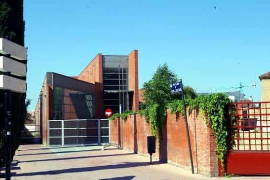Vista exterior del edificio de la Biblioteca Cardenal Cisneros con fachada de ladrillo y cielo azul