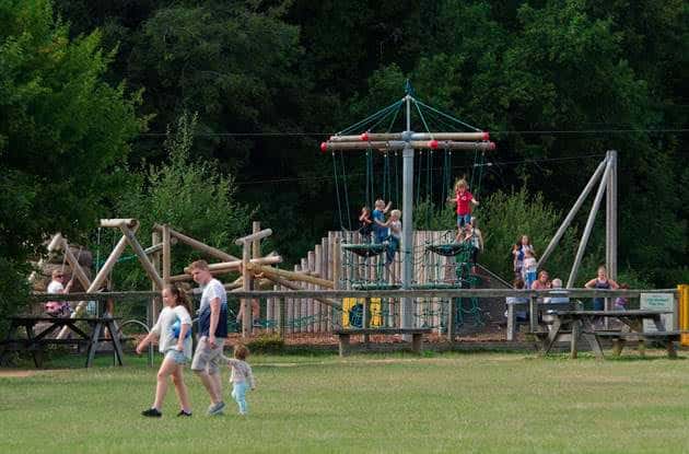 Juegos infantiles al aire libre con familias disfrutando en el parque