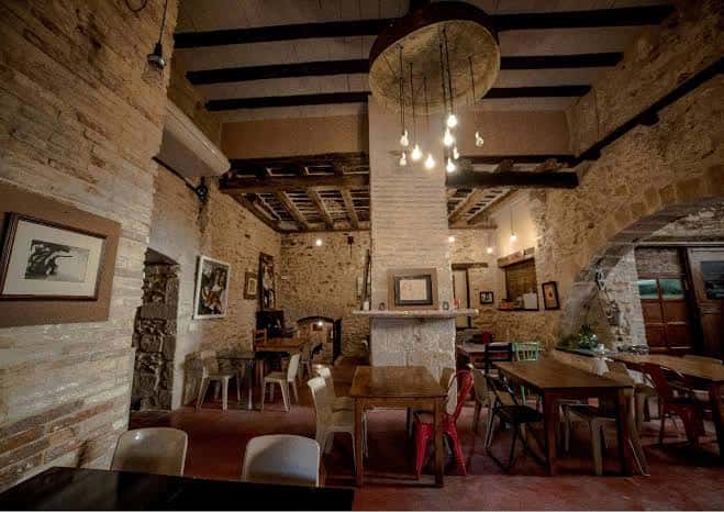 Interior del salón principal con techos de vigas de madera y decoración rústica