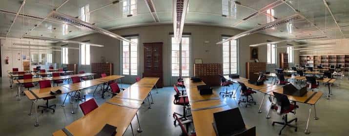 Sala de lectura amplia con mesas y sillas en la biblioteca