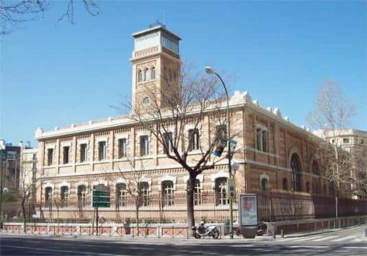 Fachada lateral de la Casa Árabe con árboles y calle en primer plano