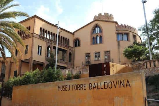 Vista exterior del Museu Torre Balldovina con su fachada amarilla y torre medieval
