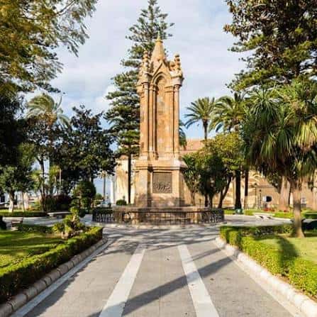 Vista panorámica de la Plaza de África con el monumento central y palmeras bajo un cielo despejado