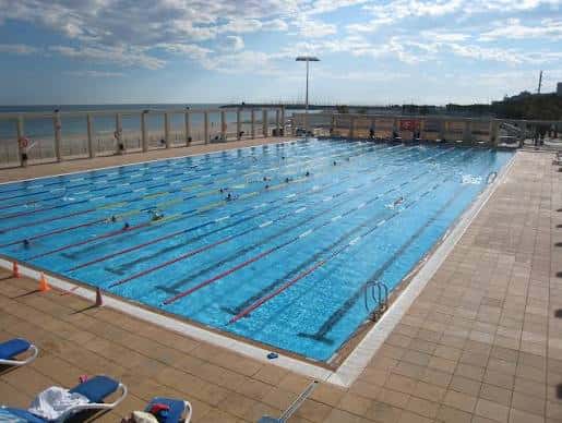 Vista general de la piscina exterior del Centre Natació Mataró con nadadores en las carriles