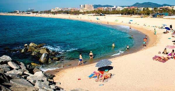 Vista panorámica de la Playa del Varador con bañistas y el mar turquesa