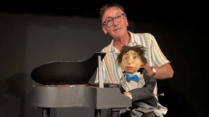 Espectáculo de marionetas con un artista y su títere en escena