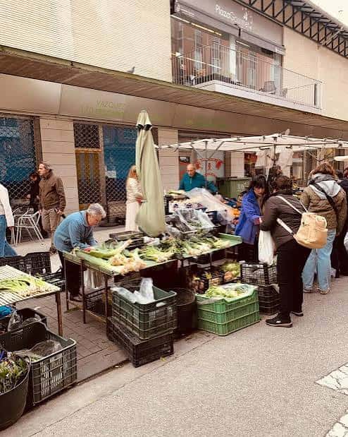 Vendedores y compradores en la zona exterior del mercado