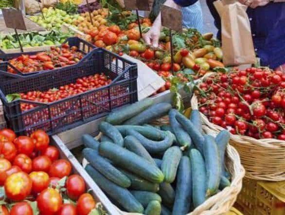 Detalle de tomates y pepinos expuestos en el mercado