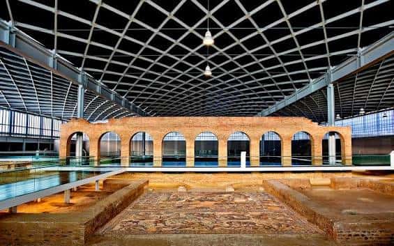 Interior de la villa con vista de los arcos y la cubierta metálica que protege las ruinas