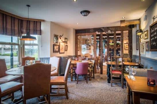 Sala principal del pub con mesas dispuestas para eventos y ambiente cálido