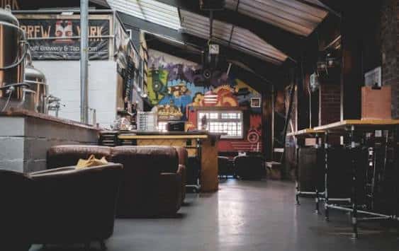 Interior industrial de Brew York con grafitis coloridos, barra y zona de estar
