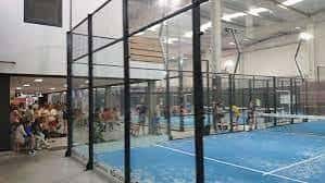 Vista interior de las pistas de pádel con jugadores en acción