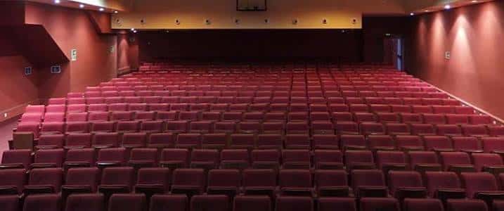 Interior del auditorio con butacas rojas y escenario