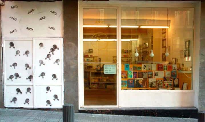 Fachada de la librería ANTI Liburudenda en Bilbao con escaparate iluminado