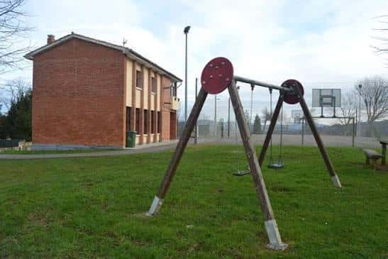 Vista exterior del Centro Social de Faro con zona de juegos infantiles y cancha de baloncesto