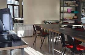 Interior del centro social: sala de reuniones o talleres con mesas y sillas