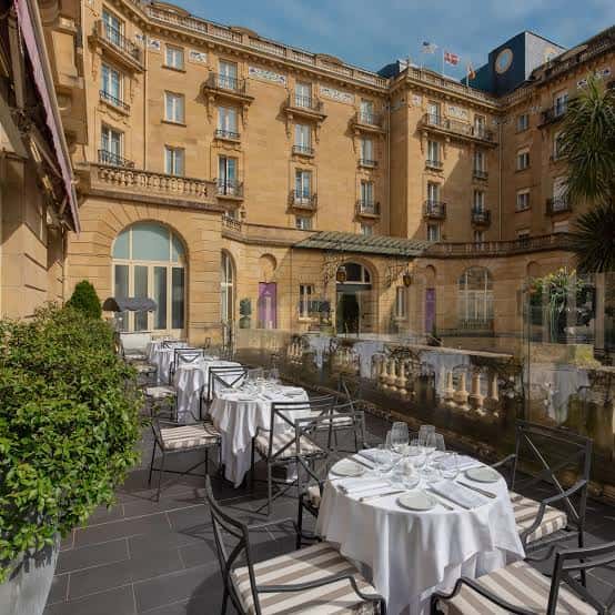 Terraza de restaurante al aire libre con mesas preparadas para cena