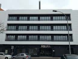 Vista frontal del edificio del Centro Ágora con estacionamiento