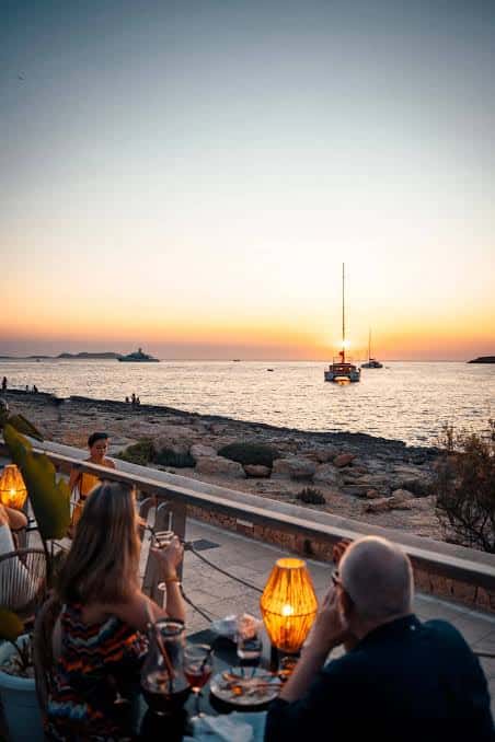 Comensales disfrutando de la cena con vista al atardecer en la terraza de Monkey Ibiza