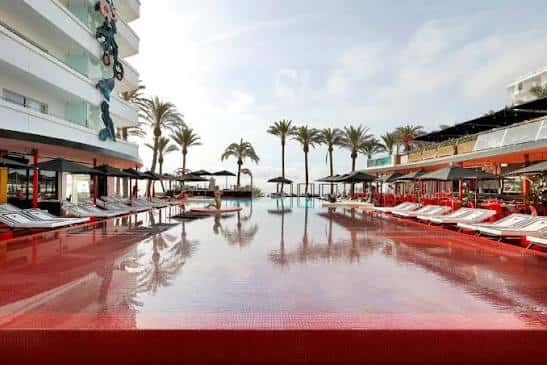 Piscina exterior del hotel con tumbonas y palmeras
