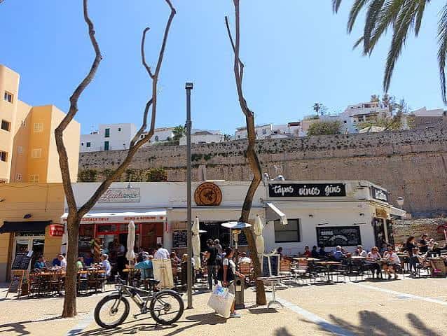 Vista de la plaza con bares y restaurantes en un día soleado