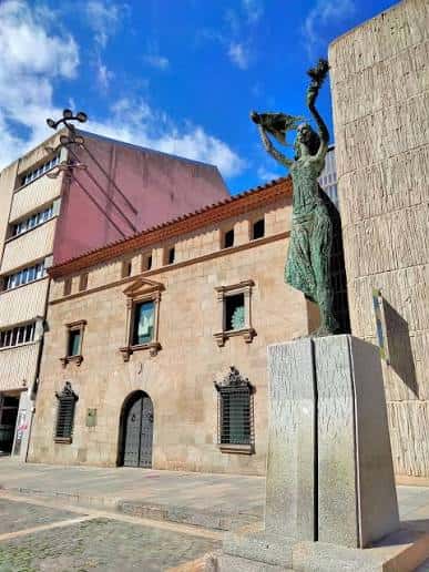 Vista de la fachada histórica del edificio del Ayuntamiento de Mataró con la escultura de la Dama de Mataró al frente