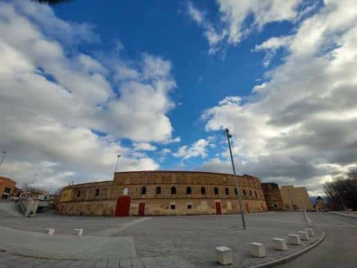 Vista exterior de la Plaza de Toros de Segovia bajo un cielo parcialmente nublado