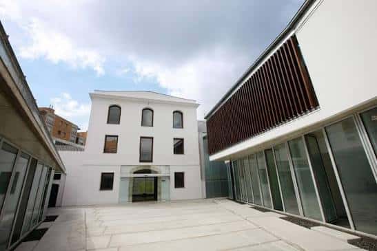 Plaza de acceso al centro con la fachada principal y la ampliación moderna a la derecha