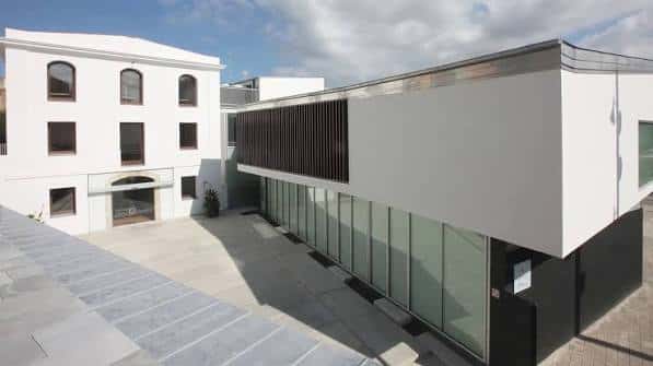 Vista aérea del complejo mostrando la integración del edificio histórico y la nueva estructura de cristal