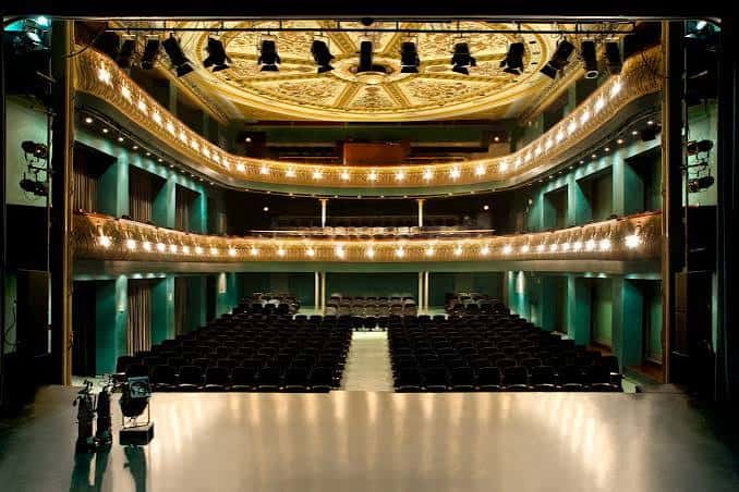 Vista panorámica del interior del Teatre Zorrilla con balcones dorados y escenario iluminado