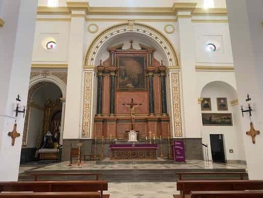 Interior de la Iglesia Mayor de la Encarnación mostrando el altar principal y el crucifijo