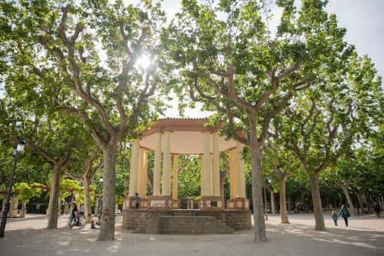 Kiosco de música rodeado de árboles frondosos en el parque