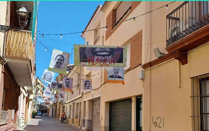 Decoración festiva con pancartas y retratos colgando en el carrer de Sant Jaume