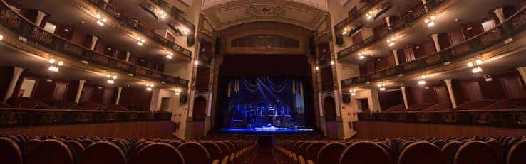 Vista panorámica del interior del Teatro Córdoba con escenario iluminado en azul