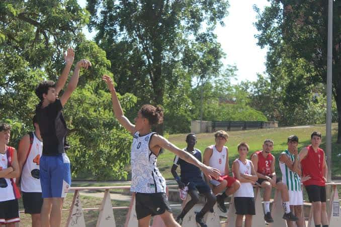 Partido de baloncesto en pista al aire libre con jugadores en acción